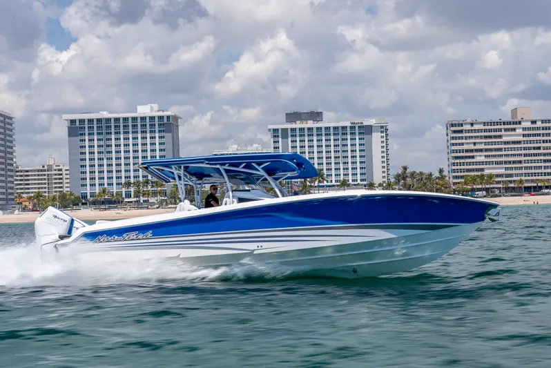  Yacht Photos Pics 2025 Nor-Tech 340 Sport boat cruising on water with cityscape background.