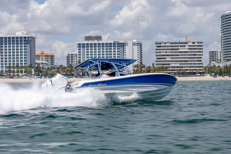  Yacht Photos Pics 2025 Nor-Tech 340 Sport boat cruising near city skyline on a sunny day.