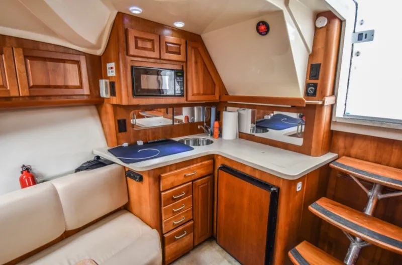 Rocky N Friends Yacht Photos Pics 2003 Luhrs 36 Open yacht interior kitchen with wood cabinetry and modern appliances.