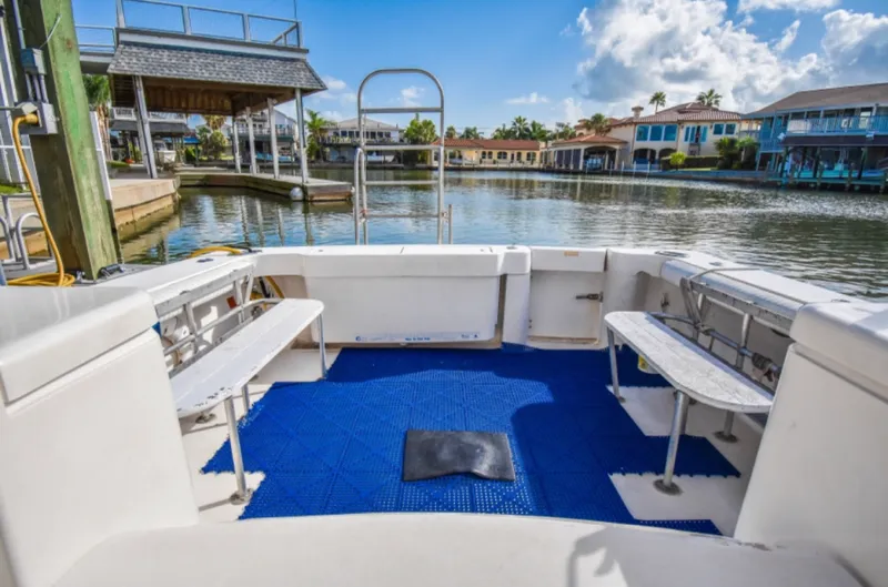 Rocky N Friends Yacht Photos Pics 2003 Luhrs 36 Open boat deck with blue flooring, docked by waterfront homes.