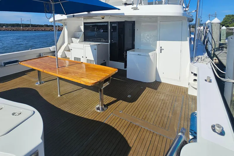 Nantucket Sleighride Yacht Photos Pics Custom 2005 Sea Raider Catamaran deck with wooden table and ocean view.