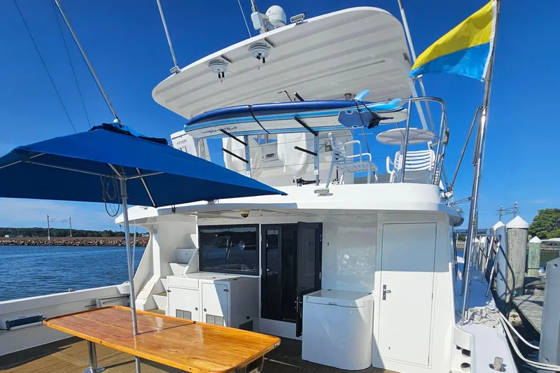 Nantucket Sleighride Yacht Photos Pics Custom 2005 Sea Raider Catamaran docked, featuring outdoor seating and blue umbrella.