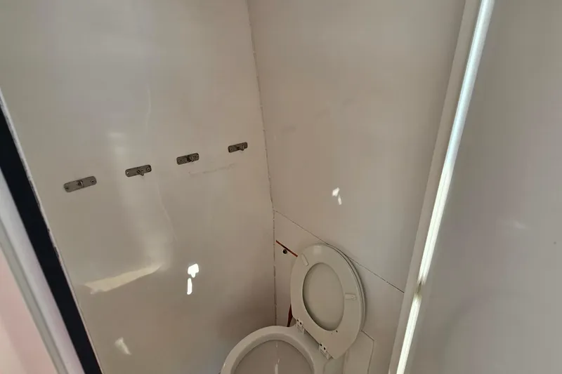 Nantucket Sleighride Yacht Photos Pics Interior of 2005 Custom Sea Raider Catamaran bathroom with white walls and toilet.
