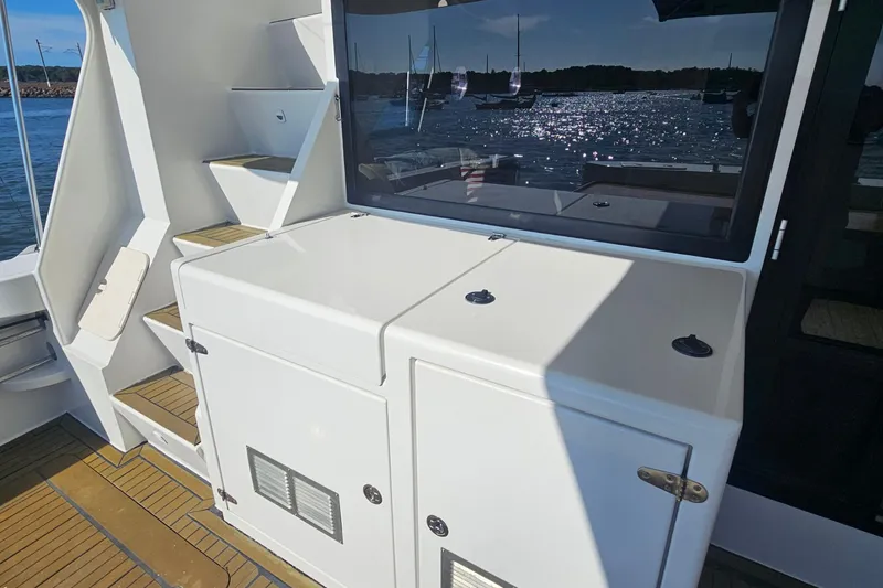 Nantucket Sleighride Yacht Photos Pics Custom 2005 Sea Raider Catamaran deck with storage and steps, overlooking a scenic harbor.