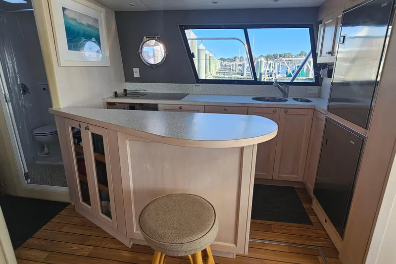 Nantucket Sleighride Yacht Photos Pics Modern kitchen interior on a 2005 Custom Sea Raider Catamaran, featuring wood cabinetry and large windows.