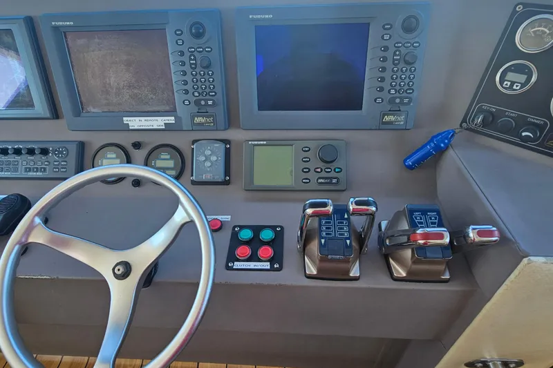 Nantucket Sleighride Yacht Photos Pics Control panel of a 2005 Custom Sea Raider Catamaran with navigation screens and steering wheel.