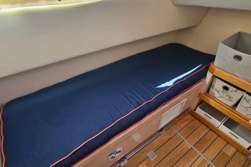 Nantucket Sleighride Yacht Photos Pics Interior of 2005 Custom Sea Raider Catamaran with blue cushioned seating and storage shelves.