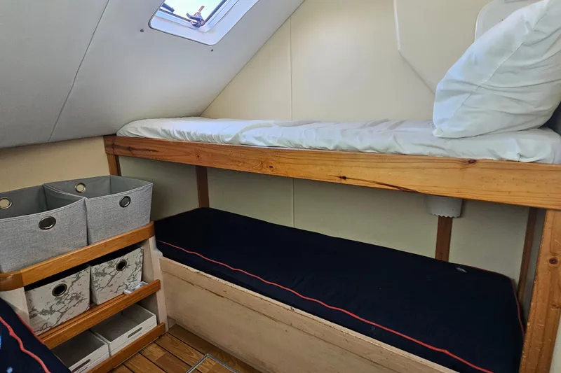 Nantucket Sleighride Yacht Photos Pics Cozy cabin interior of 2005 Custom Sea Raider Catamaran with bunk beds and storage.