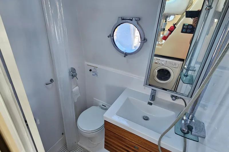 Nantucket Sleighride Yacht Photos Pics Bathroom interior of 2005 Custom Sea Raider Catamaran with sink, toilet, and porthole window.