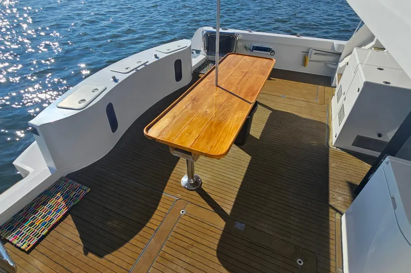 Nantucket Sleighride Yacht Photos Pics Spacious deck of 2005 Custom Sea Raider Catamaran with wooden table and ocean view.