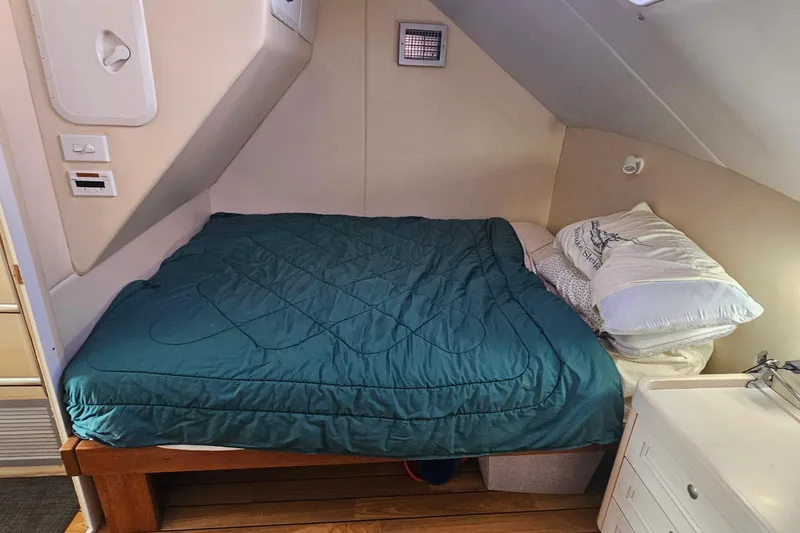 Nantucket Sleighride Yacht Photos Pics Cozy cabin bed in 2005 Custom Sea Raider Catamaran with teal bedding and wooden frame.