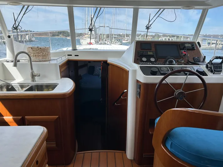 Tryst Yacht Photos Pics Interior view of 2006 Beneteau 42 Swift Trawler with helm, sink, and wooden finishes.