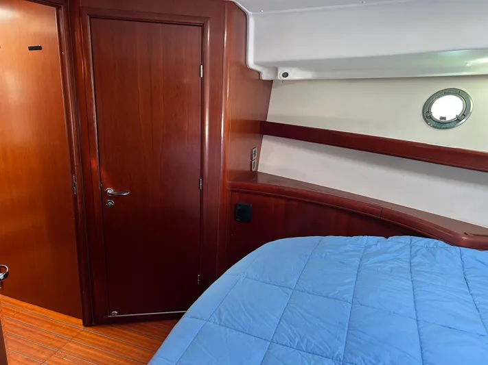 Tryst Yacht Photos Pics Interior cabin of 2006 Beneteau 42 Swift Trawler with wood finish and blue bedding.