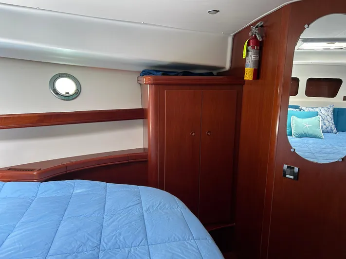 Tryst Yacht Photos Pics Cabin interior of 2006 Beneteau 42 Swift Trawler with wood finish and blue bedding.