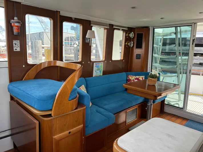 Tryst Yacht Photos Pics Interior of 2006 Beneteau 42 Swift Trawler with blue seating and wooden accents.