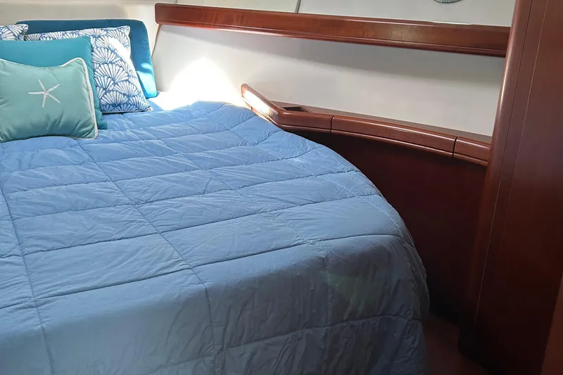 Tryst Yacht Photos Pics Cozy bedroom in 2006 Beneteau 42 Swift Trawler with blue bedding and decorative pillows.