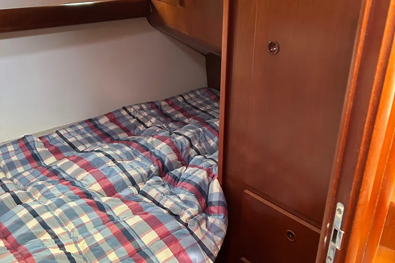 Tryst Yacht Photos Pics Cozy cabin bed in 2006 Beneteau 42 Swift Trawler with plaid bedding.