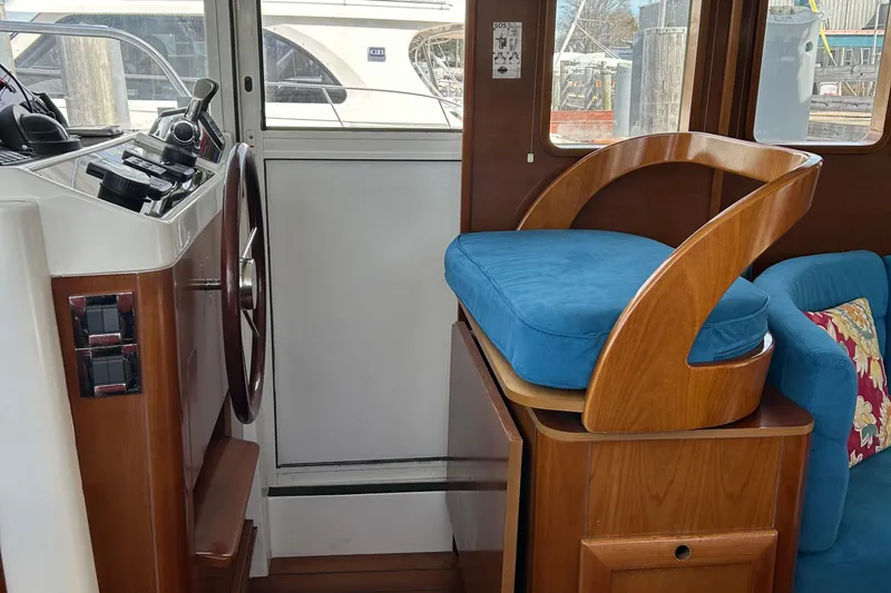 Tryst Yacht Photos Pics Interior of 2006 Beneteau 42 Swift Trawler with helm and blue cushioned seat.