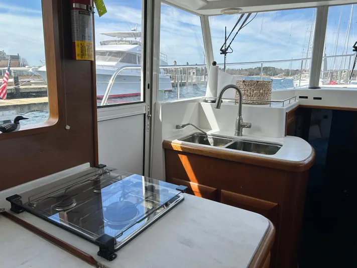 Tryst Yacht Photos Pics Interior of 2006 Beneteau 42 Swift Trawler kitchen with sink and stove, docked at marina.