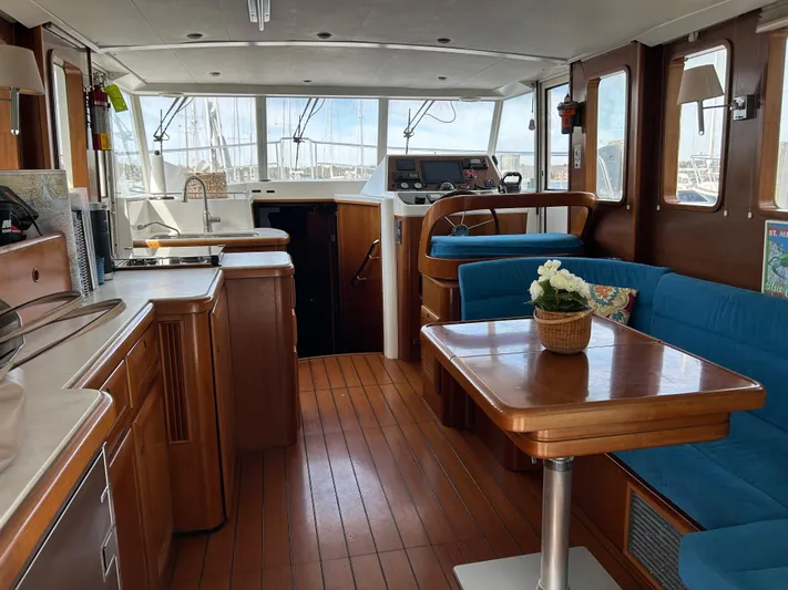 Tryst Yacht Photos Pics Interior of 2006 Beneteau 42 Swift Trawler with wood finish and blue seating.