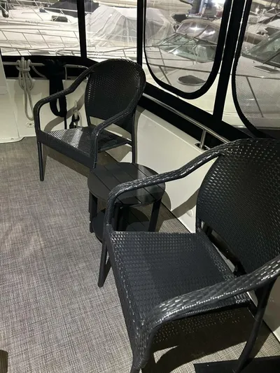 Second Knot Yacht Photos Pics 2003 Carver 396 Aft Cabin MY interior with black wicker chairs and carpeted floor.