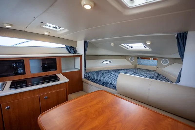 No Name - Our Trade Yacht Photos Pics Interior of 2005 Bayliner 285 boat with cozy cabin, kitchenette, and dining area.