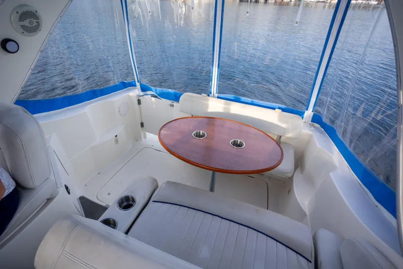 No Name - Our Trade Yacht Photos Pics 2005 Bayliner 285 boat interior with seating and table, overlooking calm water.