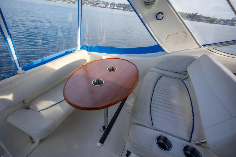 No Name - Our Trade Yacht Photos Pics Interior of 2005 Bayliner 285 boat with seating and wooden table, overlooking water.