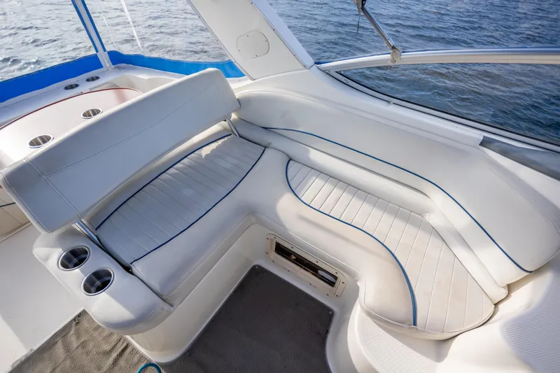 No Name - Our Trade Yacht Photos Pics 2005 Bayliner 285 boat interior with white seating and cup holders, overlooking water.