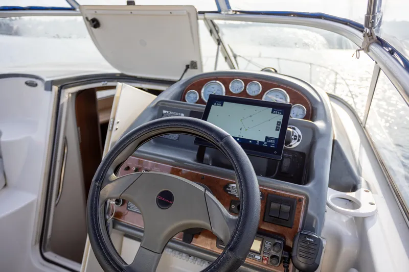 No Name - Our Trade Yacht Photos Pics 2005 Bayliner 285 boat cockpit with steering wheel and navigation system.