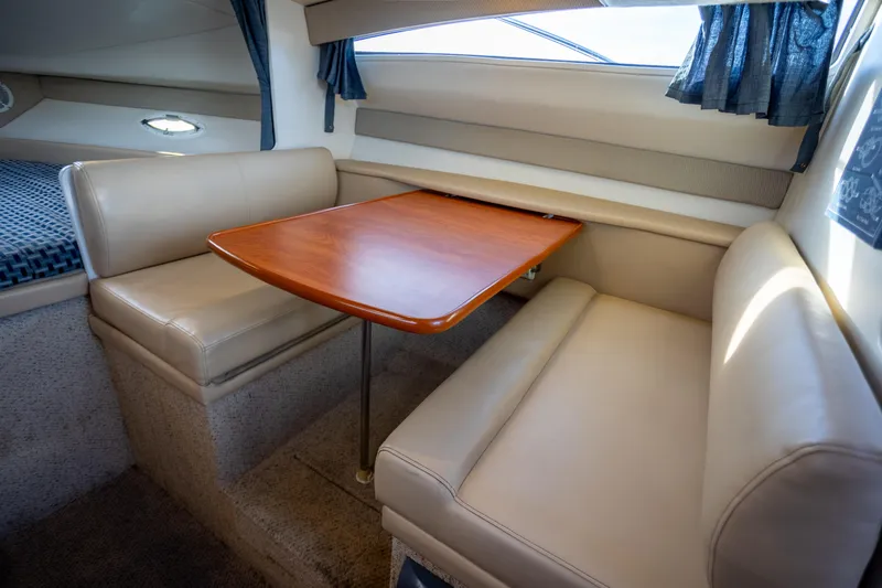 No Name - Our Trade Yacht Photos Pics 2005 Bayliner 285 interior with beige seating and wooden table in cabin.