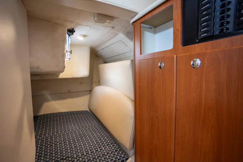No Name - Our Trade Yacht Photos Pics 2005 Bayliner 285 cabin interior with cozy bed and wooden cabinetry.