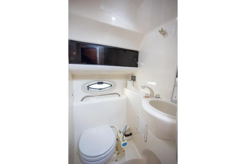 No Name - Our Trade Yacht Photos Pics 2005 Bayliner 285 boat bathroom with toilet, sink, and small window.