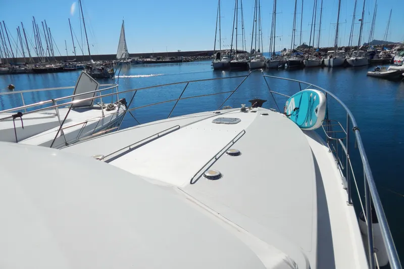  Yacht Photos Pics 1992 Fairline 50 yacht docked in a marina with sailboats in the background.