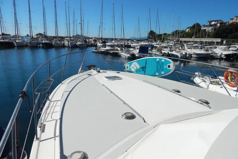  Yacht Photos Pics 1992 Fairline 50 yacht docked in marina with paddleboard on deck, surrounded by sailboats.