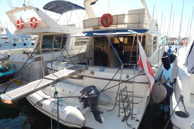  Yacht Photos Pics 1992 Fairline 50 yacht docked at marina, featuring rear deck and lifebuoys.