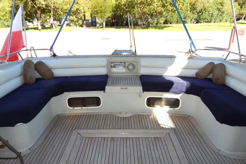  Yacht Photos Pics Spacious seating area on a 1992 Fairline 50 yacht with blue cushions and wooden deck.