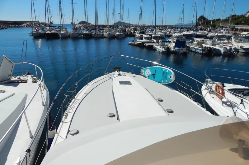  Yacht Photos Pics 1992 Fairline 50 yacht docked in a marina, surrounded by sailboats.