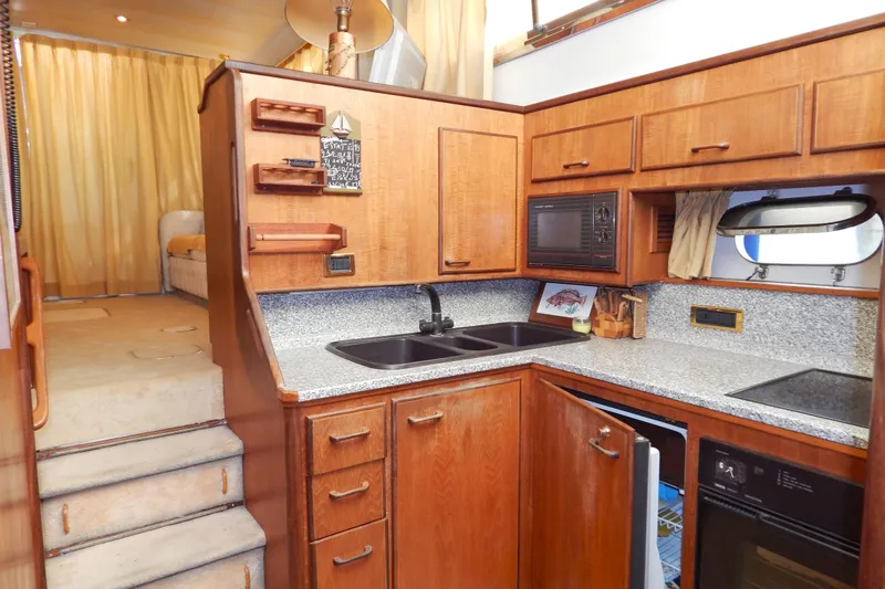  Yacht Photos Pics Interior of 1992 Fairline 50 yacht kitchen with wooden cabinets and modern appliances.