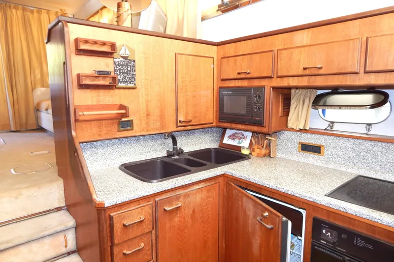  Yacht Photos Pics 1992 Fairline 50 yacht kitchen with wooden cabinets, granite countertops, and modern appliances.