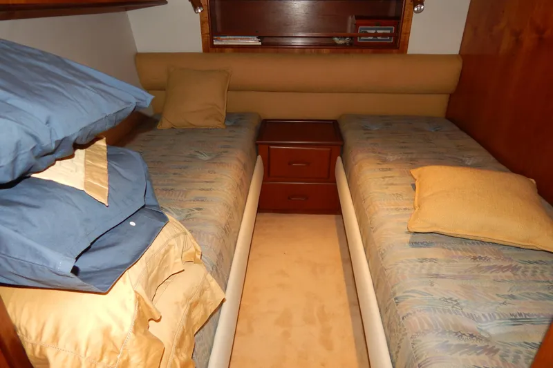  Yacht Photos Pics Twin beds in a 1992 Fairline 50 yacht cabin with wooden accents and cozy bedding.