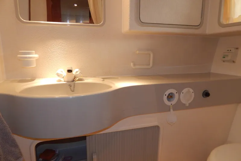  Yacht Photos Pics Bathroom sink area in a 1992 Fairline 50 yacht, featuring a mirror and storage.