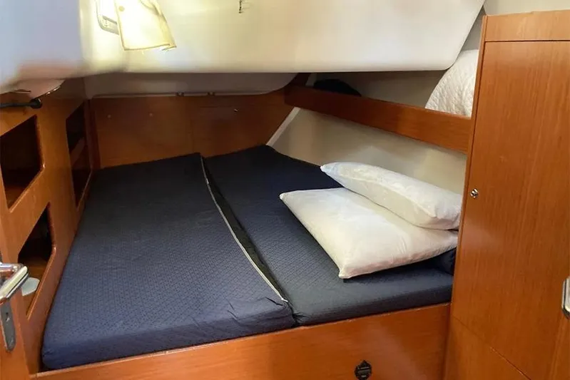  Yacht Photos Pics Cozy cabin interior of 2007 Beneteau Cyclades 50 sailboat with double bed and wooden finish.
