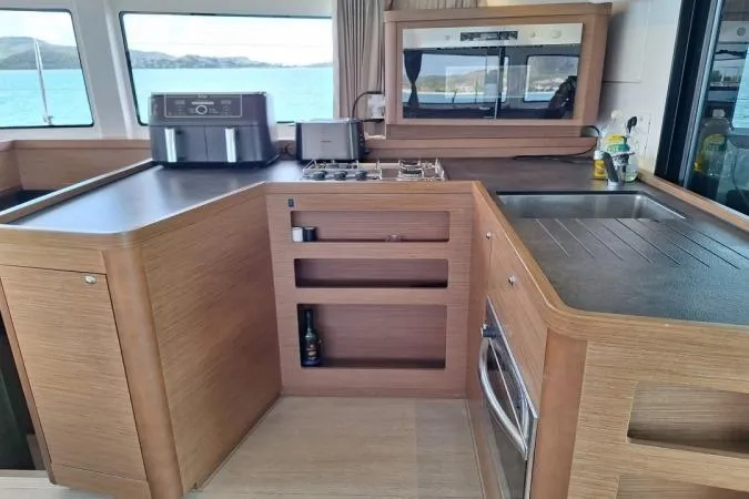 Total Eclipse Yacht Photos Pics Modern kitchen interior of 2018 Lagoon 42 catamaran with ocean view.