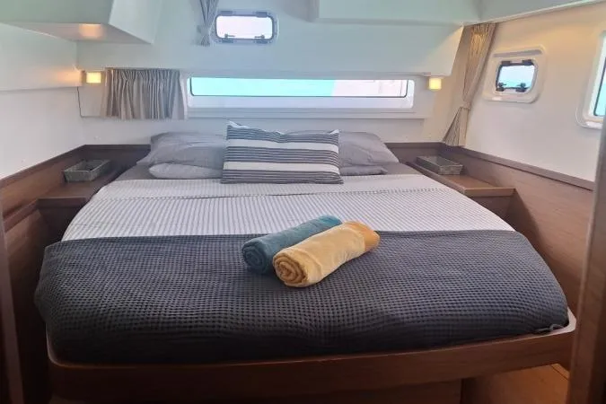 Total Eclipse Yacht Photos Pics Luxurious cabin interior of 2018 Lagoon 42 catamaran with cozy bedding and rolled towels.