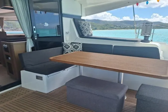 Total Eclipse Yacht Photos Pics 2018 Lagoon 42 yacht interior with seating, table, and ocean view.