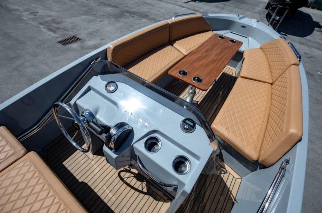 2022 Rand BREEZE boat interior with tan seating and wooden table.