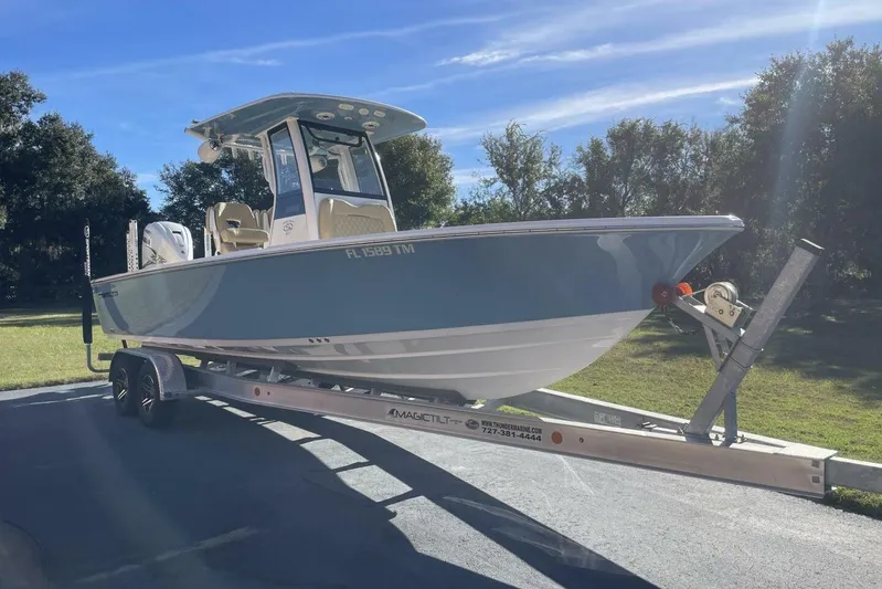  Yacht Photos Pics 2023 Sportsman Masters 267 Bay Boat on trailer, parked outdoors under clear sky.