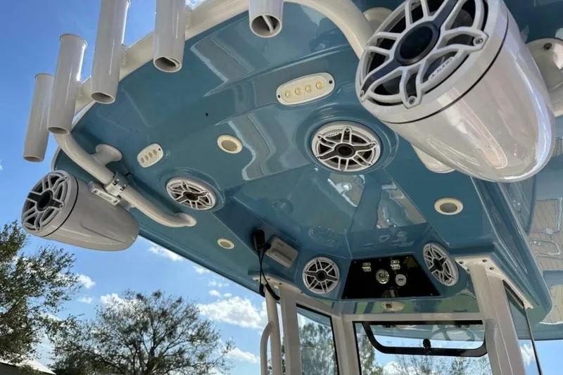  Yacht Photos Pics 2023 Sportsman Masters 267 Bay Boat with speakers and rod holders on blue T-top.