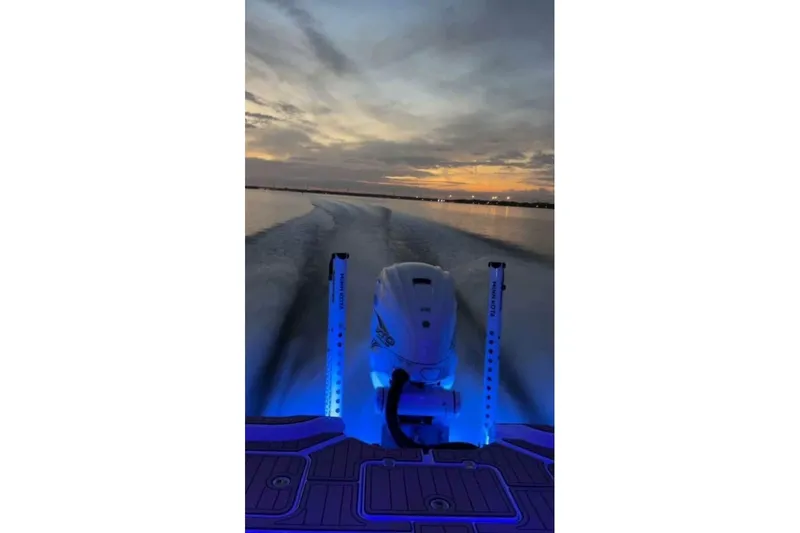  Yacht Photos Pics 2023 Sportsman Masters 267 Bay Boat cruising at sunset with illuminated deck.